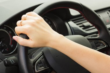 kız bir araba kullanıyor, tek elle direksiyon simidi tutar