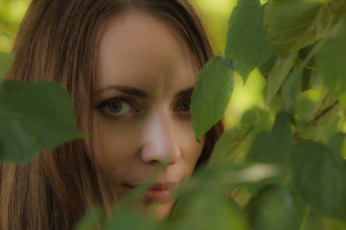 Bir ağaç bitki örtüsü içinde güzel bir kızın portresi