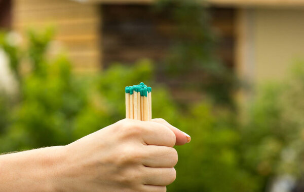 The girl holds several matches in her hand, close-up