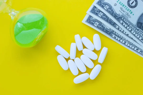 Ampulheta Com Pílulas Dinheiro Fundo Amarelo Conceito Saúde Para Dinheiro — Fotografia de Stock