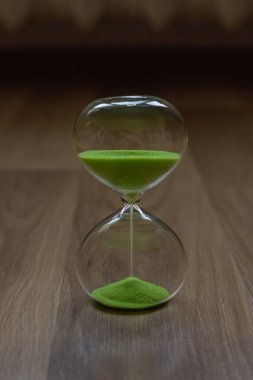 Yakın çekim, ahşap bir masa üzerinde kum saati arka plan bulanık