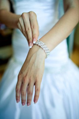 Beyaz gelinlik, güzel gelin bilezik elinde ayarlama