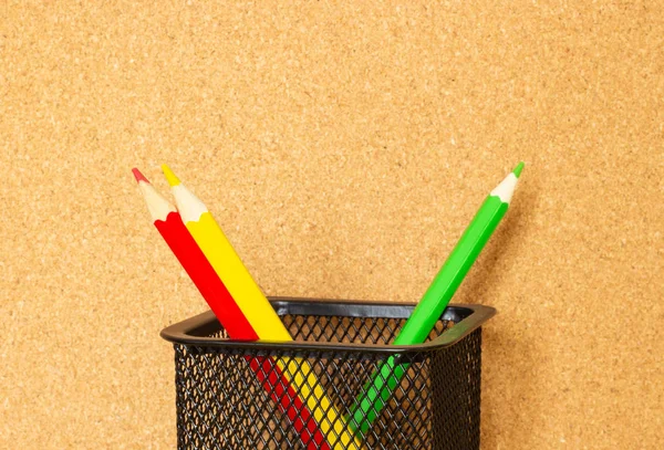 Color pencils on the background of a cork board, the concept of teaching in school
