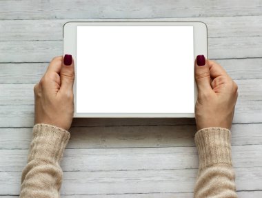 Bir tablet tutan kadın elleri izole ekranlı bilgisayar aygıtına dokunuyor.