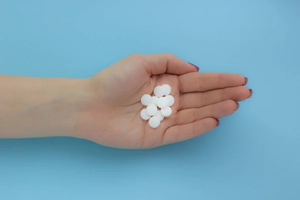 健康の概念 青色の背景に白い錠剤を保持している女性の手 — ストック写真
