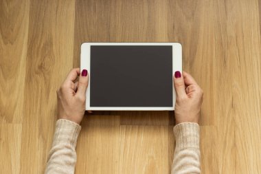 Bir tablet tutarak yerde yatarken kız