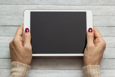 Bir tablet bir ahşap zemin, arka plan üzerinde tutan kız yakın çekim