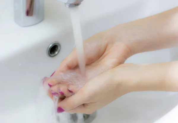 Washing of hands with soap under running water, close-up