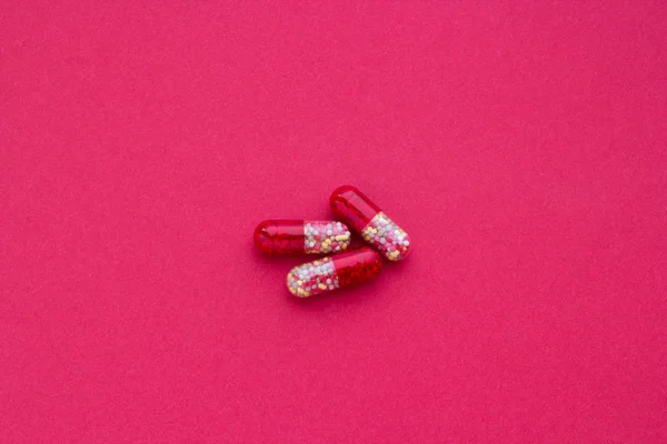 クラレットの背景に赤と黄色の錠剤クローズ アップ — ストック写真