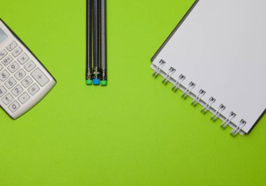 Hesap makinesi, Not defteri ve yeşil bir arka plan, üstten görünüm üzerinde siyah kalem