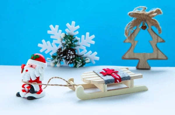 Das Konzept Der Neujahrsferien Weihnachtsmann Mit Schlitten Auf Hellblauem Grund — Stockfoto