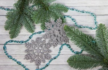 Noel kar taneleri ve çam dalları ahşap zemin, üstten görünüm