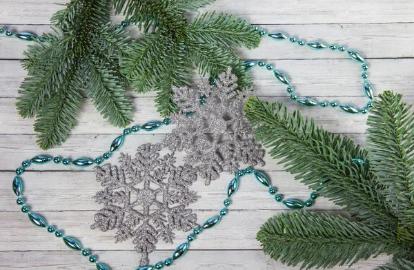 Noel kar taneleri ve çam dalları ahşap zemin, üstten görünüm