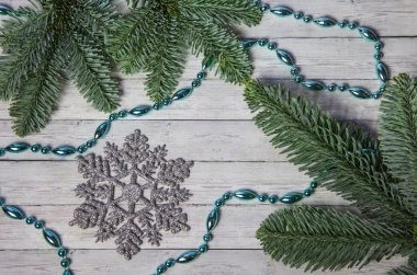 Noel kar taneleri ve çam dalları ahşap zemin, üstten görünüm