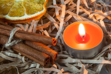 Kokulu tarçın ve portakal dilim yanan kırmızı mum, rahat bir akşam kavramı ile sopa