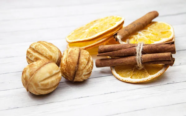 Slices of orange with cinnamon and cookies on a light wooden background