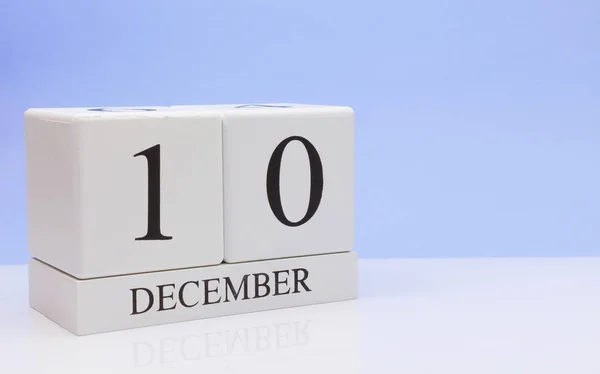 10 грудня. День 10 місяця, щоденний календар на білому столі з відображенням, з світло-блакитним фоном. Зимовий час, порожній простір для тексту — стокове фото