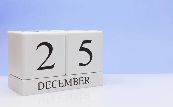 25 грудня. 25 день місяця, щоденний календар на білому столі з відображенням, з світло-блакитним фоном. Зимовий час, порожній простір для тексту — стокове фото