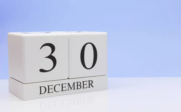 30 грудня. День 30 місяця, щоденний календар на білому столі з відображенням, з світло-блакитним фоном. Зимовий час, порожній простір для тексту — стокове фото