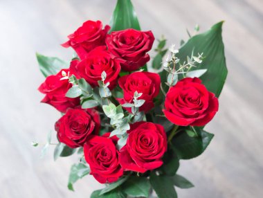 Beyaz ahşap zemin üzerinde kırmızı gül buketi