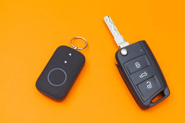 Llave de coche abierta con control remoto sobre un fondo naranja, vista superior — Foto de Stock