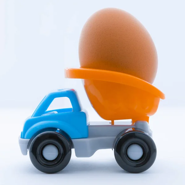 五颜六色的玩具卡车与一个鸡蛋在后面在白色背景 — 图库照片