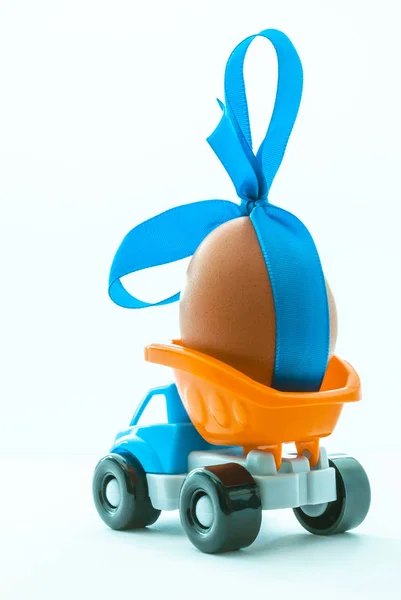 五颜六色的玩具卡车与一个鸡蛋在后面的白色背景, 侧视图 — 图库照片