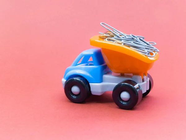 五颜六色的玩具卡车在粉红色的背景, 文具在后面 — 图库照片