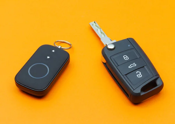 Llave de coche abierta con control remoto sobre fondo naranja — Foto de Stock