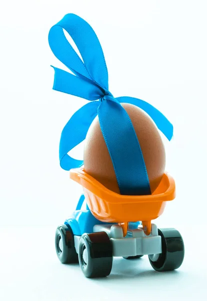 五颜六色的玩具卡车与一个鸡蛋在后面的白色背景, 后视图 — 图库照片