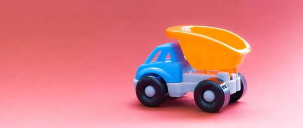 五颜六色的玩具卡车粉红色的背景, 侧视图 — 图库照片