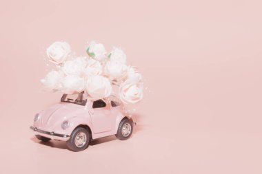 Petrozavodsk, Rusya-04 Nisan 2019: pembe arka planda beyaz güller buket ile Pembe Retro oyuncak araba. Konsept Sevgililer günü, 14 Şubat kartı, 8 Mart, uluslararası mutlu kadınlar günü