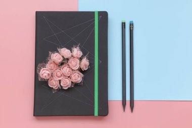 Pembe ve mavi arka planda üst görünüm, defter ve kalemler. Düz Lay Lady tarzı