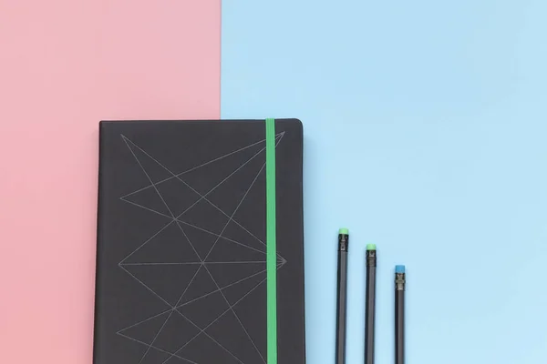 顶部视图, 粉红色和蓝色背景的笔记本和铅笔。特写 — 图库照片