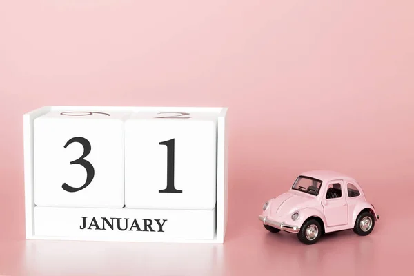 Petrozavodsk, Russia - April 06, 2019: Close-up wooden cube 31st of January. Day 31 of january month, calendar on a pink background with retro car. Winter time. Empty space for text.