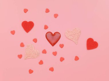 Pembe arka plan üzerinde kalplerden yapılmış desen. Düz döşeme, üst görünüm