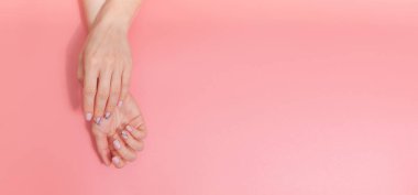 Nazik çıplak manikür. Metin için alan ile pastel pembe arka plan üzerinde Kadın eller