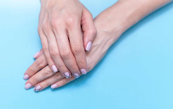 Moda mujeres de arte de la mano, mano con maquillaje de contraste brillante y uñas hermosas, cuidado de la mano. Creativa belleza foto chica sobre fondo azul — Foto de Stock