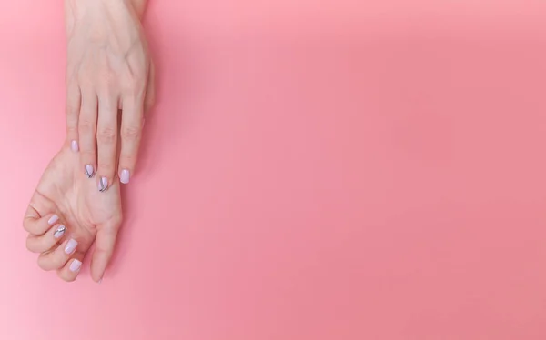 Hermosas y suaves manos femeninas sobre un fondo rosa con espacio para el texto . — Foto de Stock