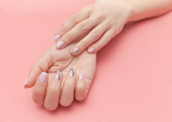 Tender hands with perfect nude manicure on trendy pastel pink background. concept of healthy and beautiful hands. — Stock Photo, Image