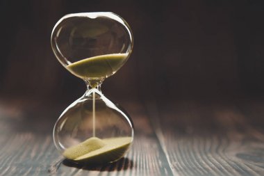 Bir cam ampul içinde düşen kum ile Kum Saati, metin için alan ile karanlık bir arka plan üzerinde zaman geçen veya kayıp zaman