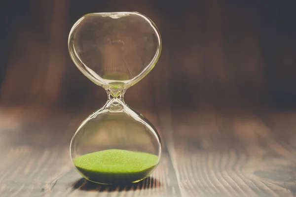 Hourglass як концепція минулого часу, втраченого часу або завершених випадків. Годинник на дерев'яному фоні . — стокове фото