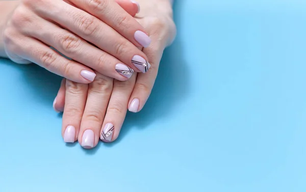 Fashionable feminine art, beautiful unique nail manicure on a blue background — Stock Photo, Image