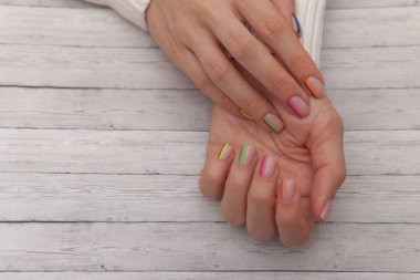 Çok renkli modern manikür, tırnak tasarımı. Yaz ruh hali, ahşap arka plan üzerinde.