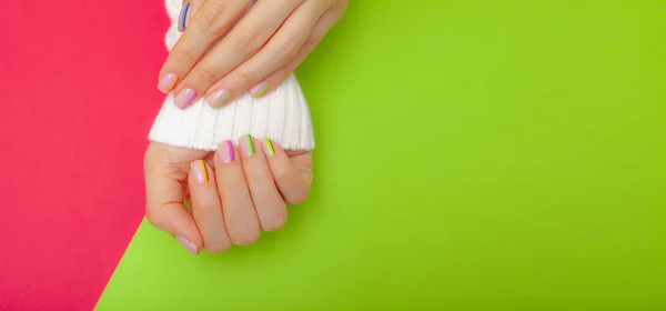 Elegante manicure feminina na moda. As mãos da bela jovem sobre fundo vermelho e verde. Espaço para texto — Fotografia de Stock