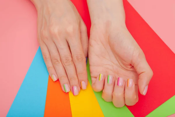 Moderno arco-íris de manicure elegante ou humor de verão, em uma mesa rosa com envelopes coloridos vista superior — Fotografia de Stock