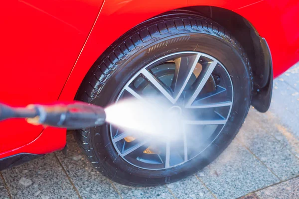 Lavado manual de coches con agua a alta presión, limpieza de ruedas — Foto de Stock