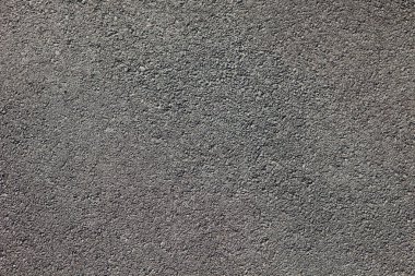 Küçük kayalar ile pürüzsüz koyu gri asfalt kaldırım dokusu