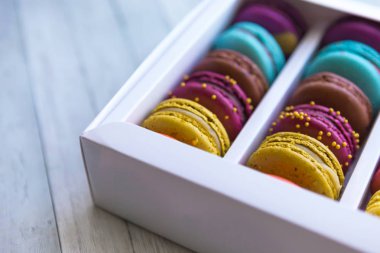 Macaroons çerezleri renk her türlü. Ahşap arka plan üzerinde kutuiçinde Macaroons.
