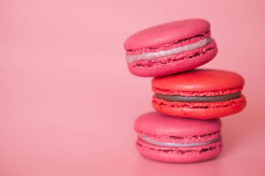 Şık bir mercan arka plan yakın çekim bir yığın pembe macaroons, tatil için bir tedavi olarak Fransız çerezleri